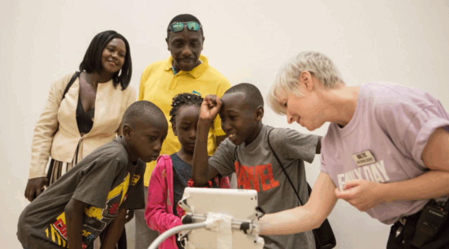 A family of 5 gather around a screen