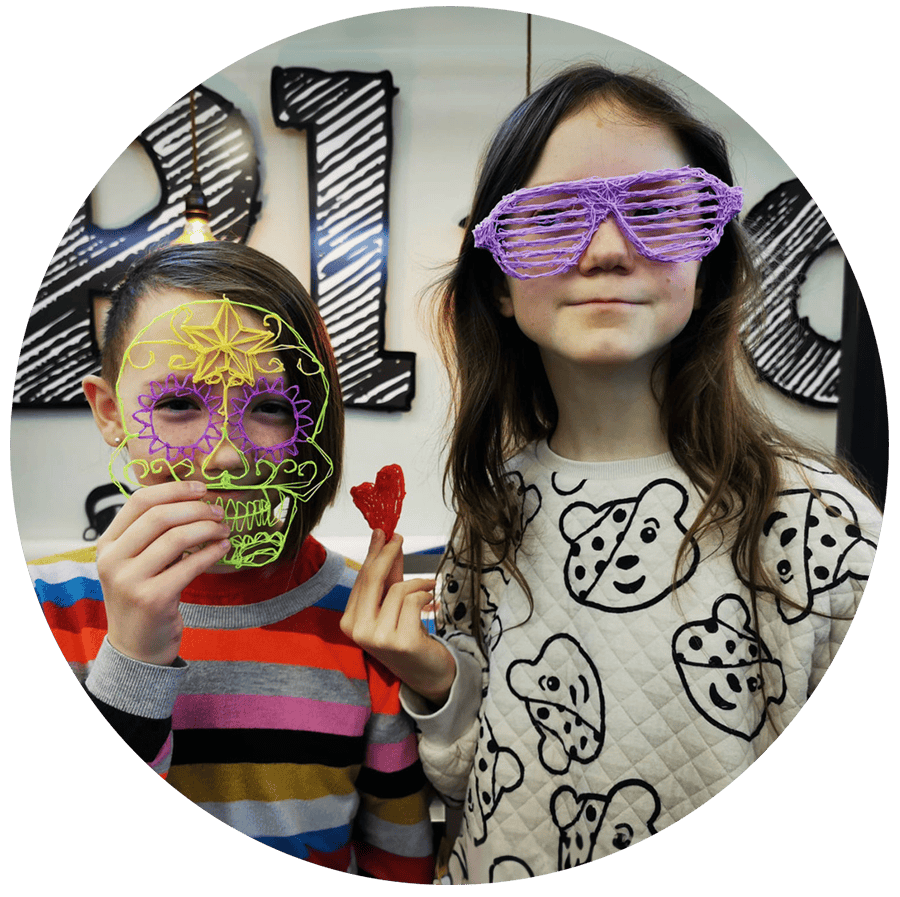 Two children wear colourful sunglasses and a skull mask that may have been 3D printed
