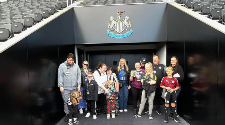 A group of adults and young people inside St James Park Stadium